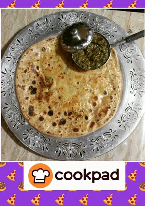 A picture of Aaloo ka paratha(potato flat bread) with mint chutney.