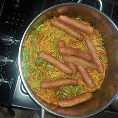 A picture of Spaghetti jollof and beef sausage.