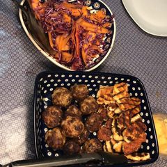 A picture of Lambs kofta with grilled halloumi, tzatzici and pickled carrot and red cabbage.