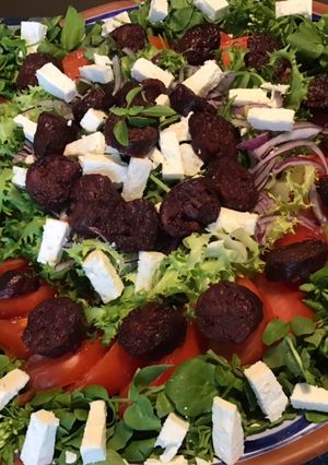 Une photo de Trio de salades (frisée,roquette,cresson) tomate,oignon rouge et chorizo noir à la feta