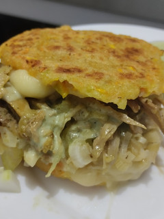 Una foto de Arepa🫓de calabacin🥯y zanahoria rellena de pollo🍗queso🧀cebolla🧅caramelizada y salsa de ajo🧄🌿🥯