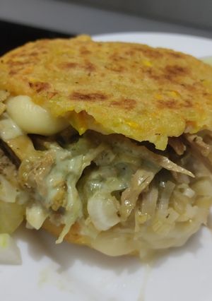 Una foto de Arepa🫓de calabacin🥯y zanahoria rellena de pollo🍗queso🧀cebolla🧅caramelizada y salsa de ajo🧄🌿🥯