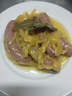 Una foto de Salchichas con vino y cebolla