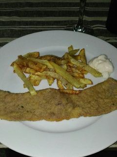 Una foto de Bistec empanado con patatas fritas deliciosas