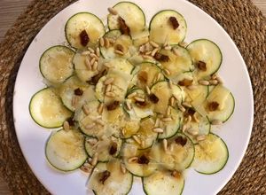 Una foto de Carpaccio de calabacín con piñones, dátiles y emulsión de vinagre y aceite