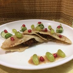A picture of Stuffed pita bread with stuffed cauliflower kababs served with pomegranate grape sauce.
