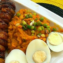 A picture of Beans paired with fried plantains and hard boiled eggs.