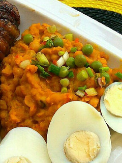 A picture of Beans paired with fried plantains and hard boiled eggs.