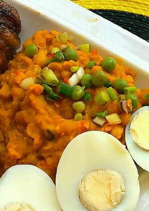 A picture of Beans paired with fried plantains and hard boiled eggs.