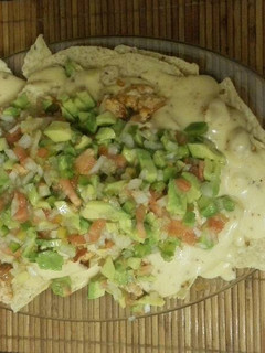 Una foto de Nachos con salsa cheddar