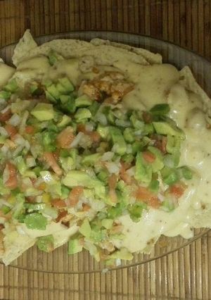 Una foto de Nachos con salsa cheddar