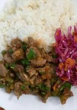 A picture of Beef stew served with rice and red cabbage.