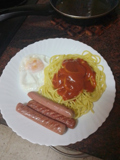 Una foto de Pasta al ajillo con huevo frito y salchichas