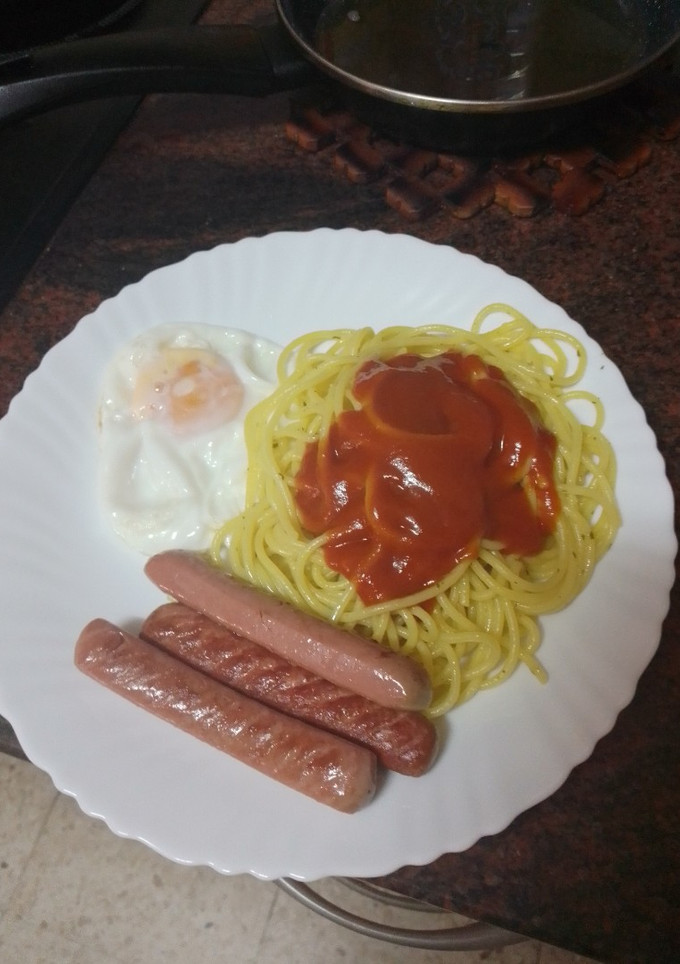 Una foto de Pasta al ajillo con huevo frito y salchichas