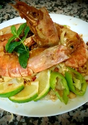 A picture of Pad thai with king prawns and lemon slices and tagliatelle rice.