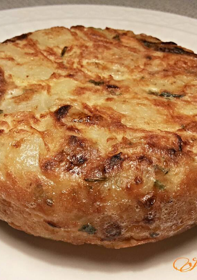 Una foto de Tortilla de patatas con cebollas, ajos y perejil