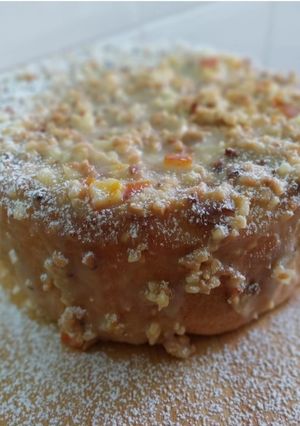 Una foto de Bizcocho genovés con cobertura crujiente de chocolate blanco, almendras y naranja confitada