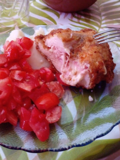 Una foto de Milanesa rellena de jamón y queso con ensalada de tomate y morón