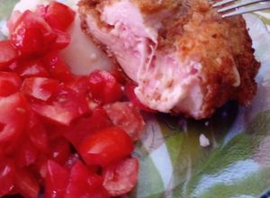 Una foto de Milanesa rellena de jamón y queso con ensalada de tomate y morón