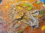Una foto de carne deshebrada en tomatillo