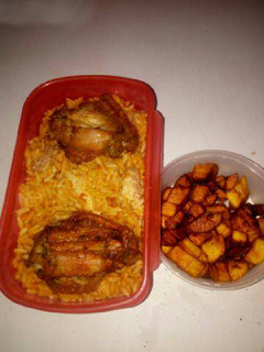 A picture of Jollof rice with chicken and fried plantain.
