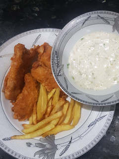 A picture of Fish and chips with tarter sauce.