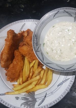 A picture of Fish and chips with tarter sauce.