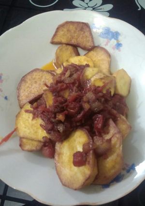 A picture of Fried potatoes and tomato sauce.