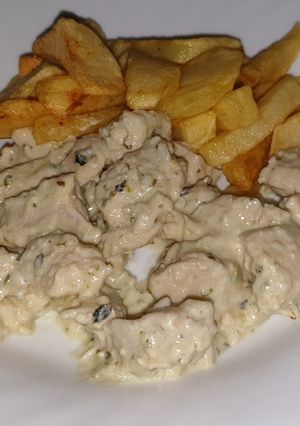 Una foto de Pollo troceado al roquefort con patatas
