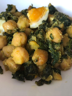 Una foto de Salteado especiado de espinacas con garbanzos y huevo