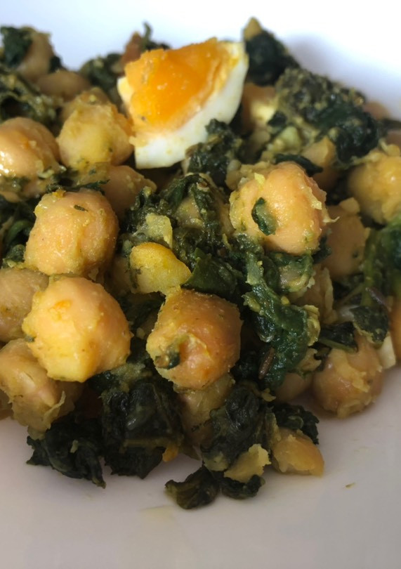 Una foto de Salteado especiado de espinacas con garbanzos y huevo