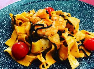 Una foto de Cintas de pasta al huevo con langostinos y espagueti nero de merluza