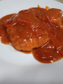 Una foto de Merluza con tomate y pimientos asados