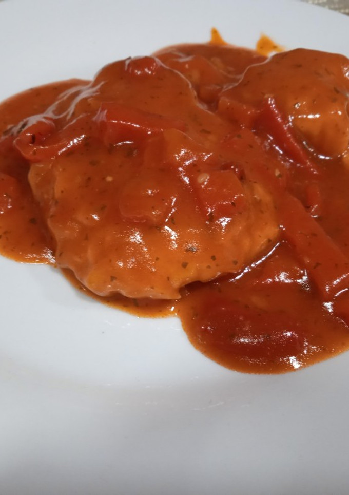 Una foto de Merluza con tomate y pimientos asados
