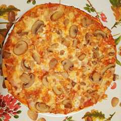 Una foto de Pizza de masa casera con jamón cocido, atún y champiñones