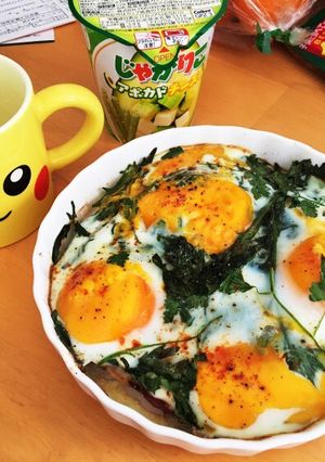 A picture of Baked eggs on seasonal greens and prosciutto.