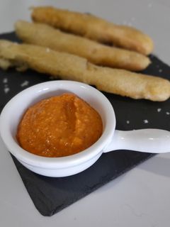 Una foto de Calcots asados en tempura con salsa romesco