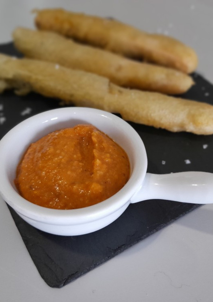 Una foto de Calcots asados en tempura con salsa romesco