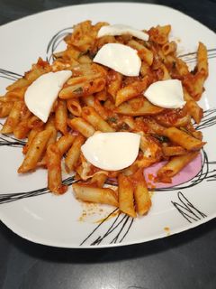 Una foto de Macarrones con tomate, albahaca y mozzarella