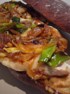 Una foto de Bocadillo de Lomo con caramelizado de cebolla y ajetes + Hummus con tomates aromatizados