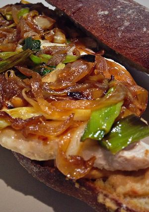 Una foto de Bocadillo de Lomo con caramelizado de cebolla y ajetes + Hummus con tomates aromatizados