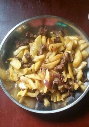 A picture of Fried beef with potatoes.