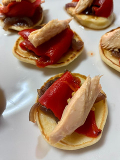 Una foto de Blinis de cebolla caramelizada, pimiento del piquillo y filetes de melva
