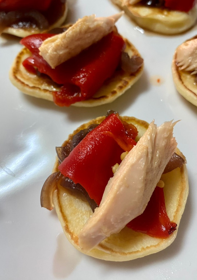Una foto de Blinis de cebolla caramelizada, pimiento del piquillo y filetes de melva