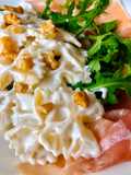 Farfalle al gorgonzola e noci su letto di prosciutto crudo e rucola