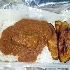 A picture of White rice and stew and fried plantain.