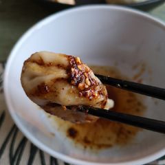 A picture of White bean dumplings dip in sichuan dipsauce.