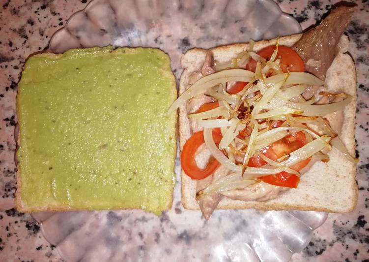Sándwich integral con guacamole, melva, cebolla y tomate cherry