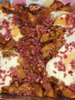 Una foto de Patatas especiadas al horno con huevo y virutas de jamón
