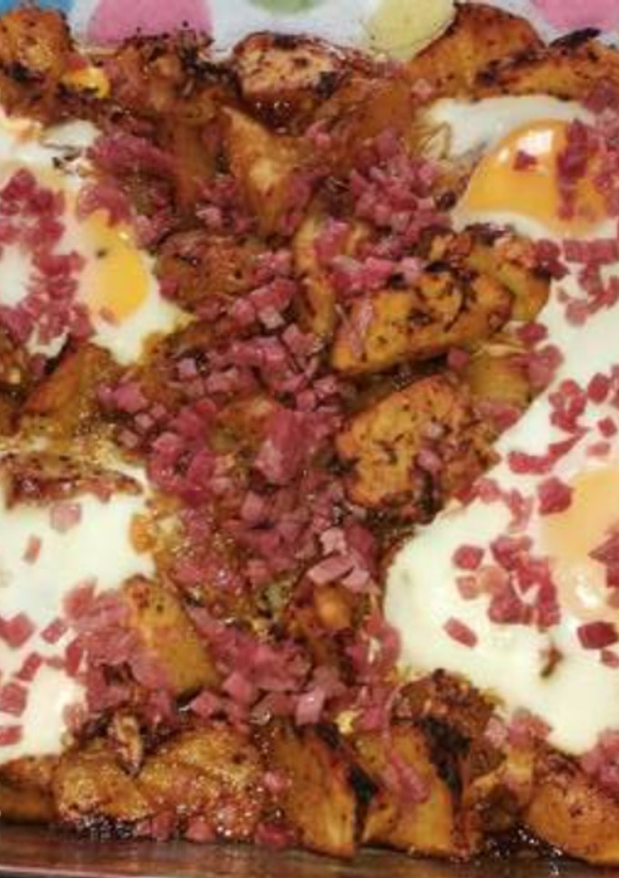 Una foto de Patatas especiadas al horno con huevo y virutas de jamón